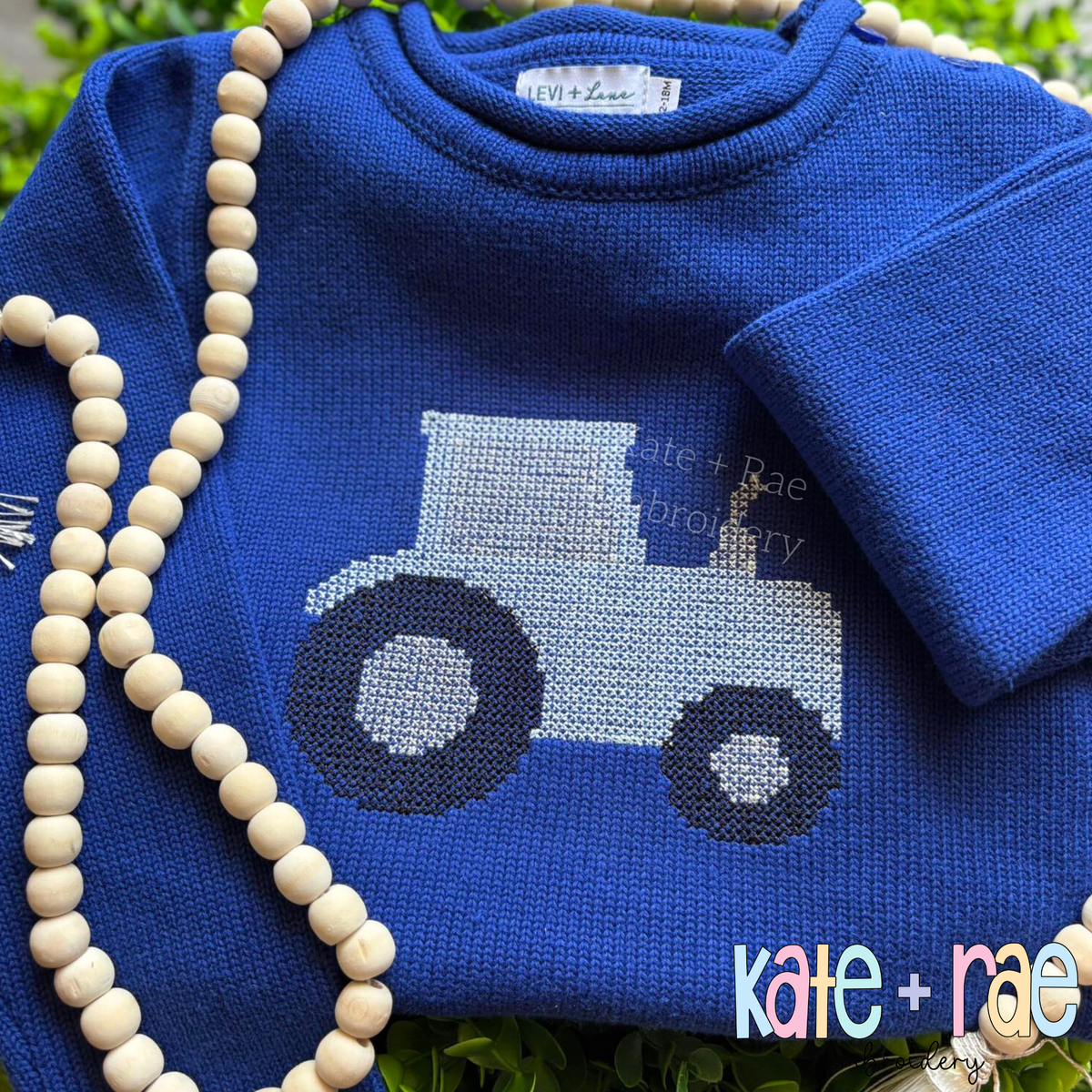 Tractor Cross Stitch Embroidery Design: Light blue tractor cross stitch on a royal blue roll neck sweater