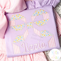 Quilt Block Bow 2 Zigzag Applique Embroidery Design: Floral and gingham quilt block bow applique above the name Lizzie in lavender script on a purple shirt
