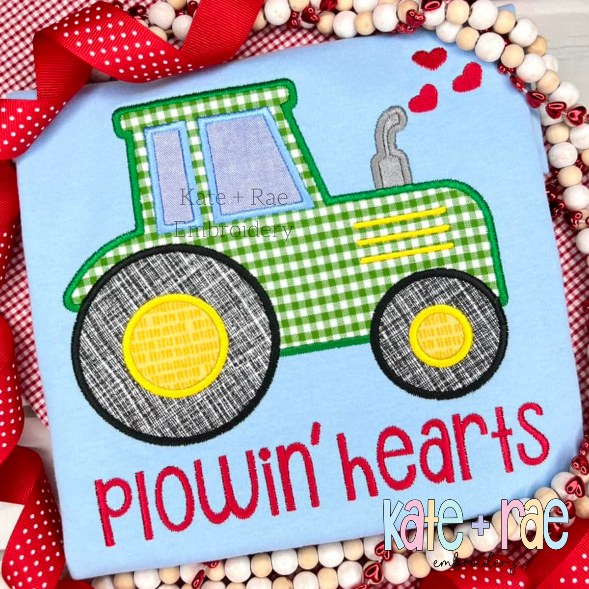 Tractor with Hearts Satin Stitch Applique Embroidery Design: Green gingham tractor applique with hearts above the words plowin' hearts in red on a light blue shirt