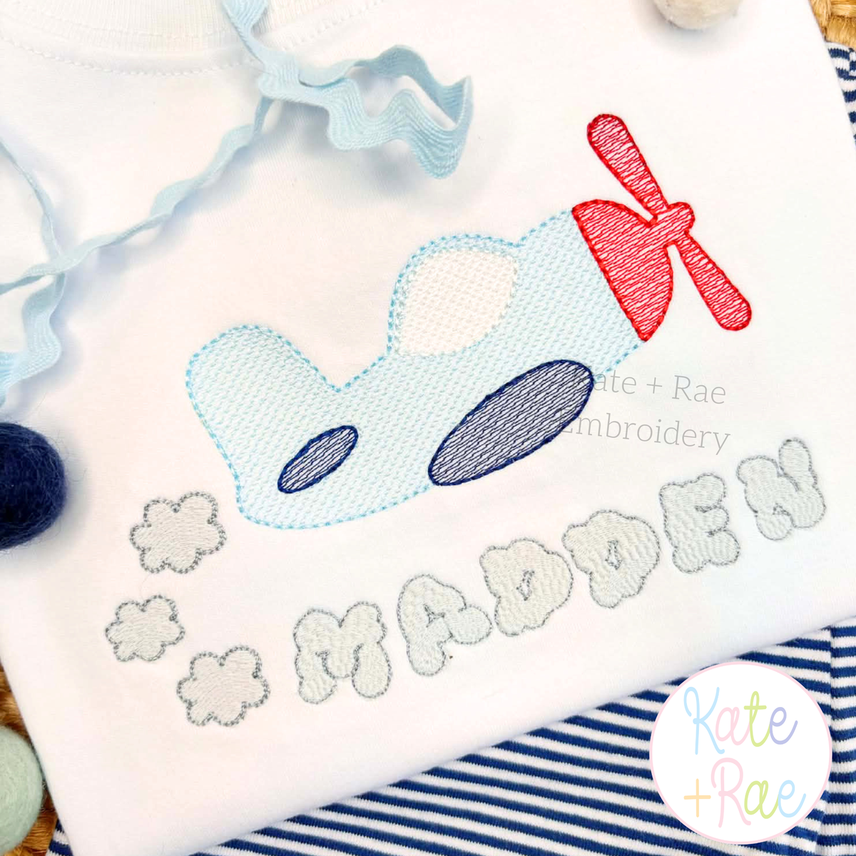 Airplane Sketch Stitch Embroidery Design: Close-up of a blue sketch airplane with clouds above MADDEN in gray letters