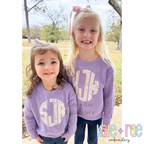 Scalloped Monogram Satin Stitch Applique Embroidery Font: Two girls wearing lavender sweatshirts with floral scalloped monograms