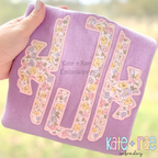 Scalloped Monogram Satin Stitch Applique Embroidery Font: Scalloped monogram in pastel floral satin applique on a lavender sweatshirt