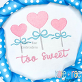 Heart Sucker with Bow Mini Fill Stitch Embroidery Design: Three pink heart suckers with blue bows above the words too sweet in pink script on a white shirt