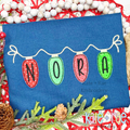 Christmas Lights Bean Stitch Applique Embroidery Font: Christmas light bulbs spelling NORA hanging from a white strand on a navy shirt