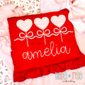 Heart Sucker Trio with Bows Satin Stitch Applique Embroidery Design: Three pink striped heart sucker appliques tied with white bows above the name amelia in white script on a red shirt