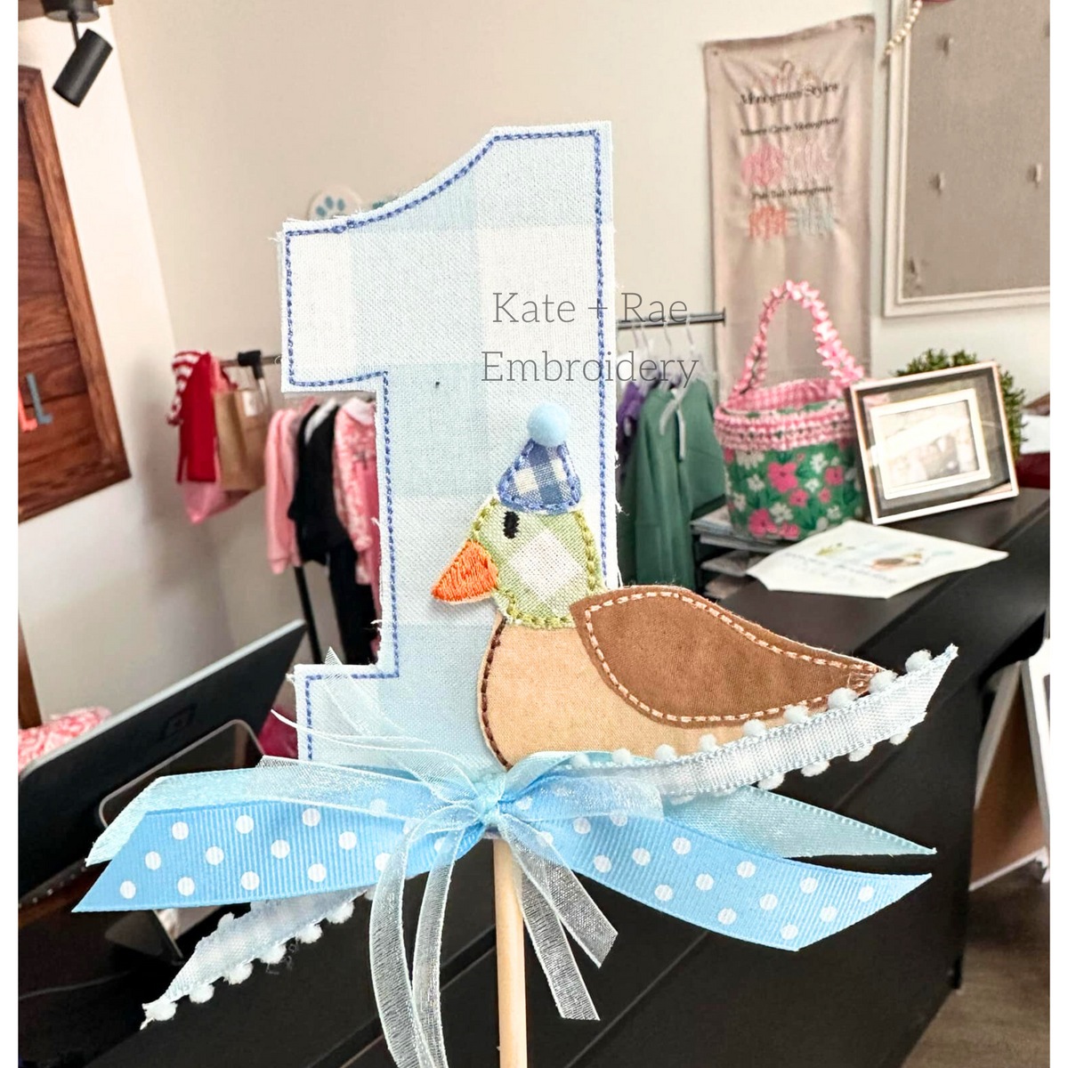 Mallard Duck Bean Stitch Applique Cake Topper Add On Embroidery Design: Close-up of a blue gingham number 1 cake topper with a duck applique wearing a party hat
