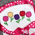 Tulip Party Bean Stitch Applique Embroidery Design: Five polka dot and gingham tulip appliques in pink, yellow, purple, and red on a white shirt