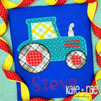 Teal patterned tractor applique with red wheels above the name Steve in red on a blue shirt