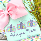 Butterfly Trio Sketch Stitch Embroidery Design: Three pastel sketch stitch butterflies above the name Adelynn Renee in purple script on a mint shirt