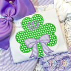 Shamrock with Kinley Bow Satin Stitch Applique Embroidery Design: Green polka dot shamrock applique with a striped lavender bow and a purple monogram on a white shirt