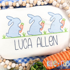 Boy's Easter Bunny with Carrots Trio Sketch Stitch Embroidery Design: Close-up of three blue sketch bunnies holding carrots above the name Luca Allen