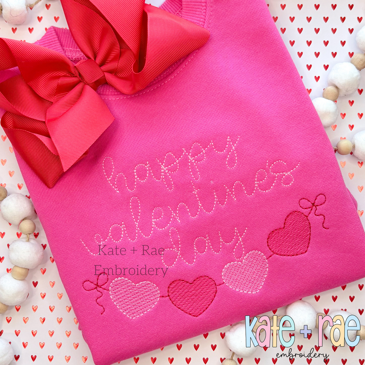 Heart Banner Sketch Stitch Embroidery Design: The words happy valentine's day in pink above a heart banner on a hot pink sweatshirt