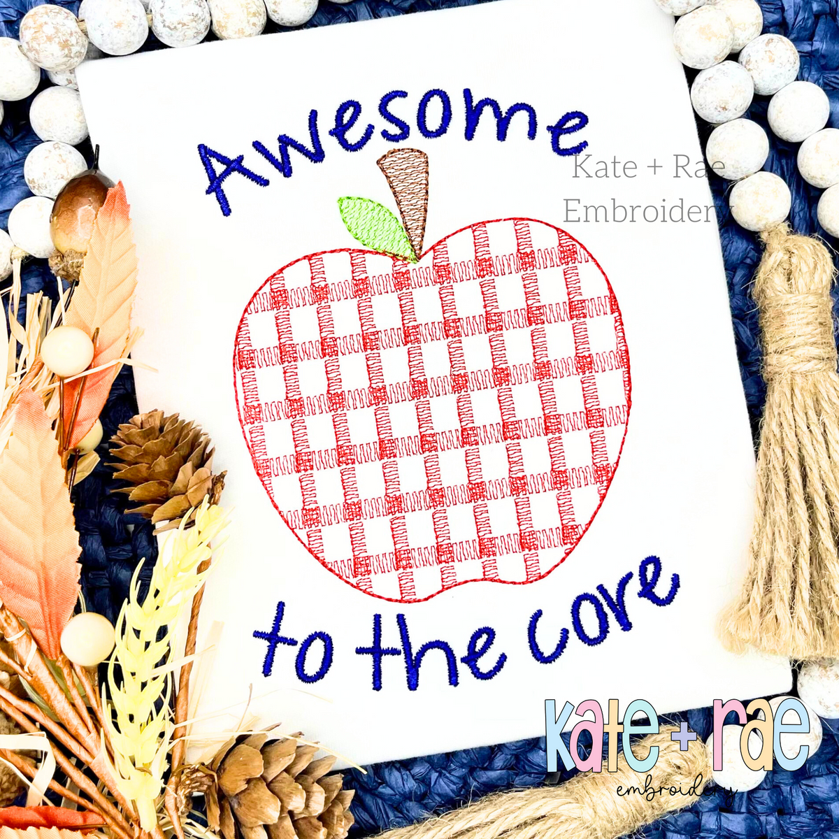 Boy's Single Plaid Apple Filled Embroidery Design: Red plaid apple between the words Awesome and to the core in navy script on a white shirt