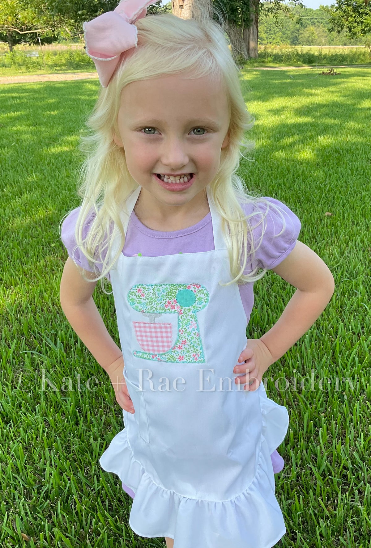 Baking Mixer Zigzag Applique Embroidery Design: Smiling girl wearing a white ruffled apron with a floral stand mixer applique