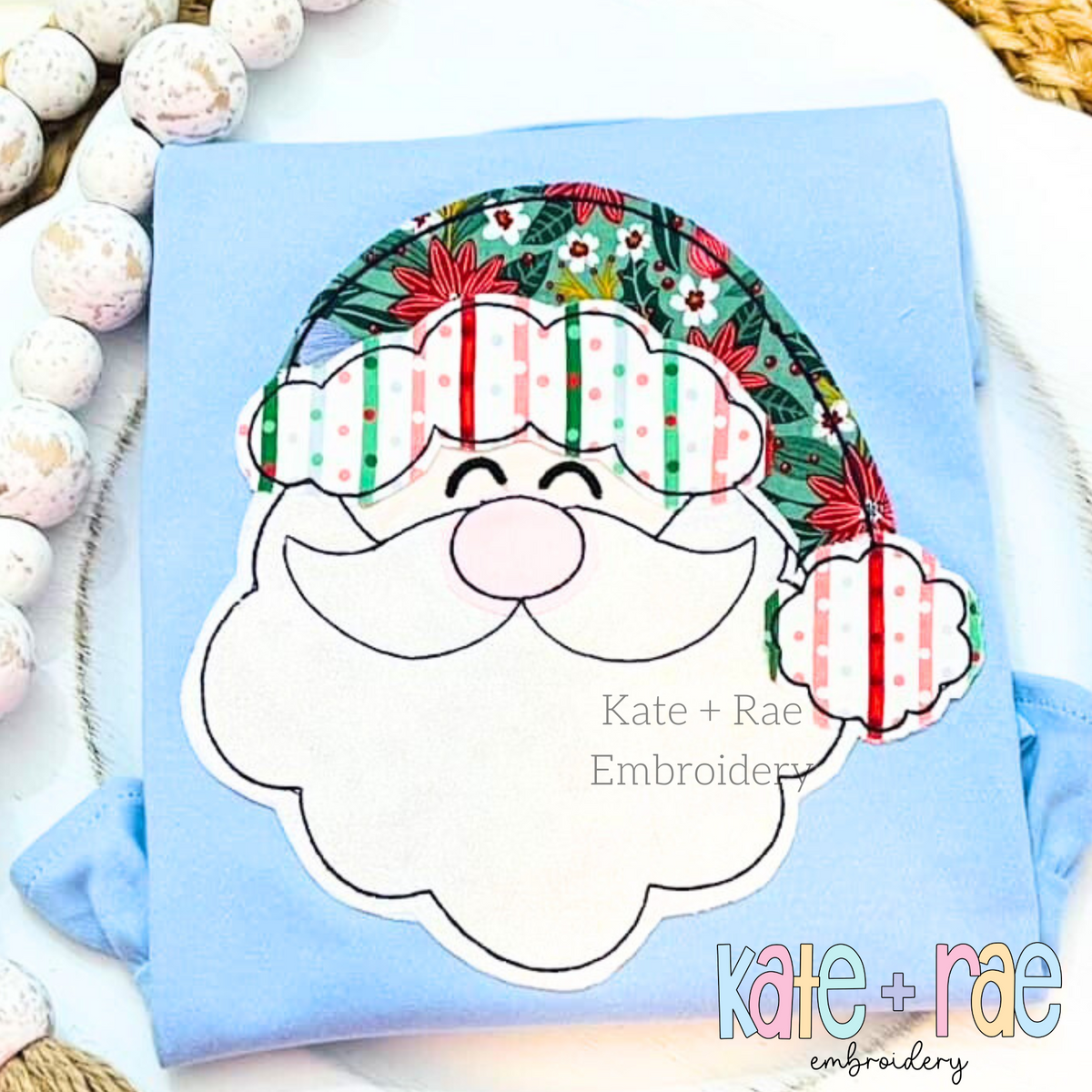 Santa Claus Bean Stitch Applique Embroidery Font: Santa face applique with a striped and floral hat on a light blue shirt