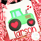 Valentine's Day Heart Tractor Zigzag Applique Embroidery Design: Green tractor applique with red heart wheels above the name larson in red on a white shirt