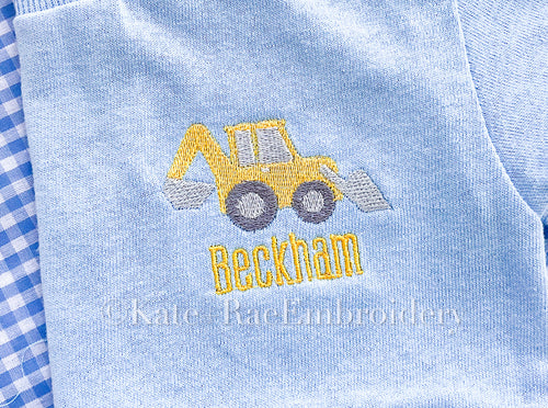 Backhoe Mini Fill Embroidery Design: Small yellow backhoe above the name Beckham stitched on a light blue shirt