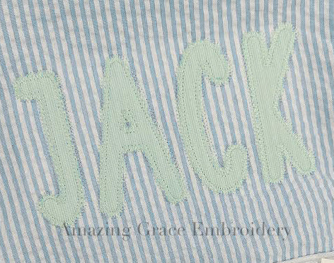 Simple Life Zigzag Stitch Applique Embroidery Font: Close-up of the name Jack in mint zigzag applique letters on blue seersucker