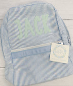 Simple Life Zigzag Stitch Applique Embroidery Font: The name Jack in mint applique letters on a blue seersucker backpack