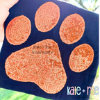 Paw Print Zigzag Stitch Applique Embroidery Design: Orange sequin paw print applique on a navy shirt
