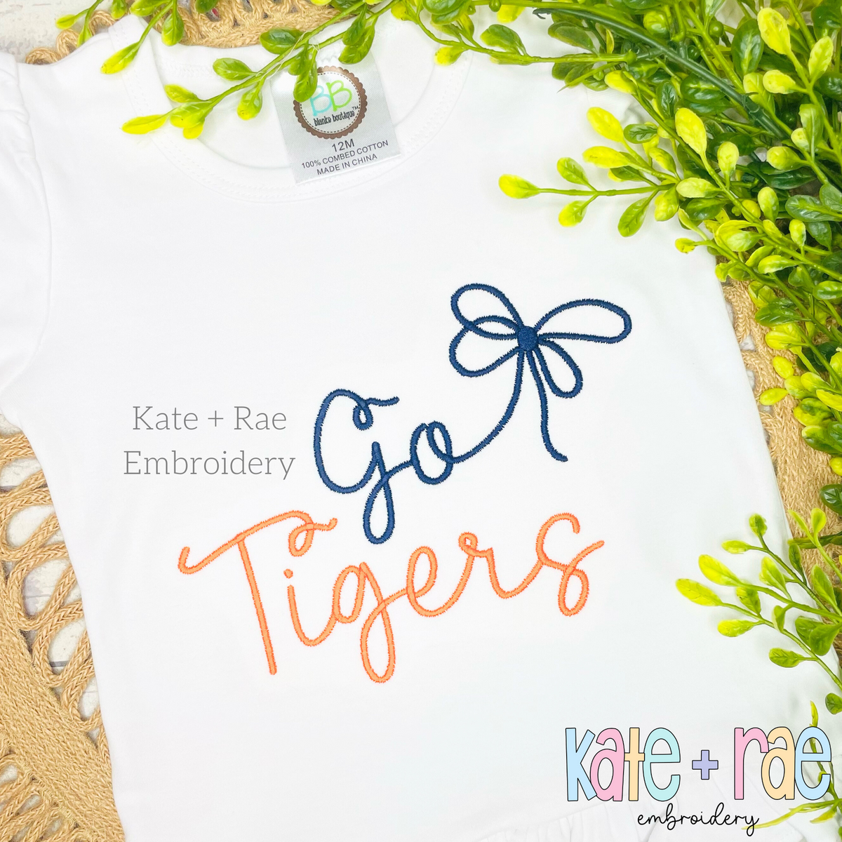 Preppy Go Tigers Embroidery Design: The words Go Tigers in navy and orange script with a navy bow on a white shirt