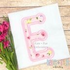 Dottie Satin Stitch Applique Embroidery Font: Pink floral applique letter E on a white shirt