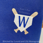 Baseball Frame Mini Fill Embroidery Design: Home plate frame with crossed bats around a blue letter W on a navy shirt