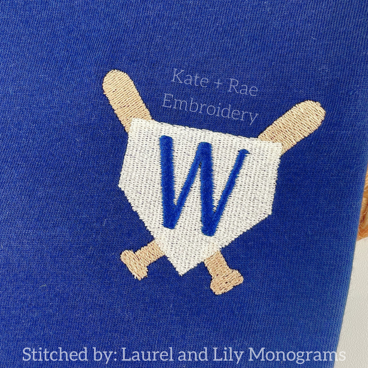 Baseball Frame Mini Fill Embroidery Design: Home plate frame with crossed bats around a blue letter W on a navy shirt