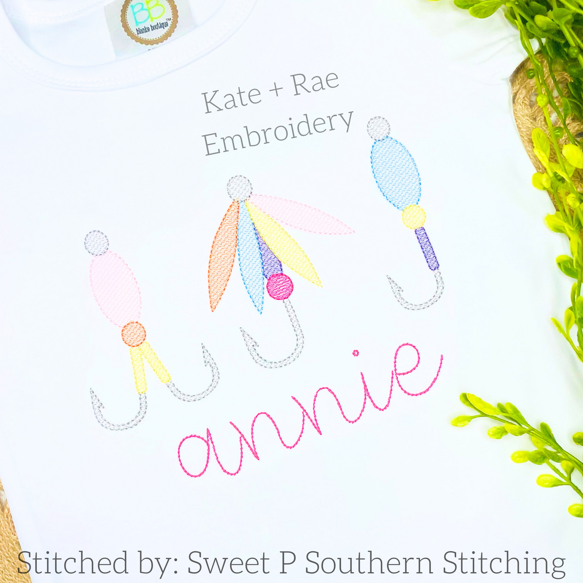 Fishing Lure Trio Sketch Stitch Embroidery Design: Three pastel sketch stitch fishing lures above the name annie in pink script on a white shirt