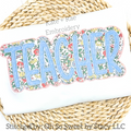 Teacher Double Satin Stitch Applique Embroidery Design: The word TEACHER in light blue applique letters with a floral print outline on a white sweatshirt