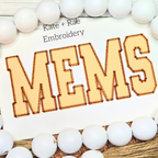 Varsity Zigzag Stitch Applique Embroidery Font: The word MEMS in tan collegiate zigzag applique letters on white fabric