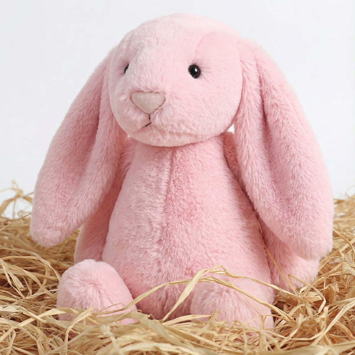 Embroidered Easter Bunnies: Pink plush bunny with long floppy ears sitting in straw