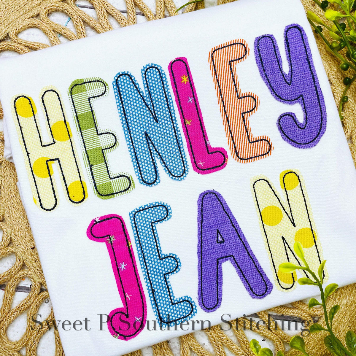 Simple Life Bean Stitch Applique Embroidery Font: The name Henley Jean in colorful patterned applique letters on a white shirt