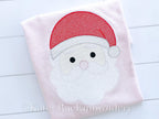 Santa Cross Stitch Sketch Embroidery Design: Cross stitch Santa face with a red hat and white beard stitched on a light pink shirt