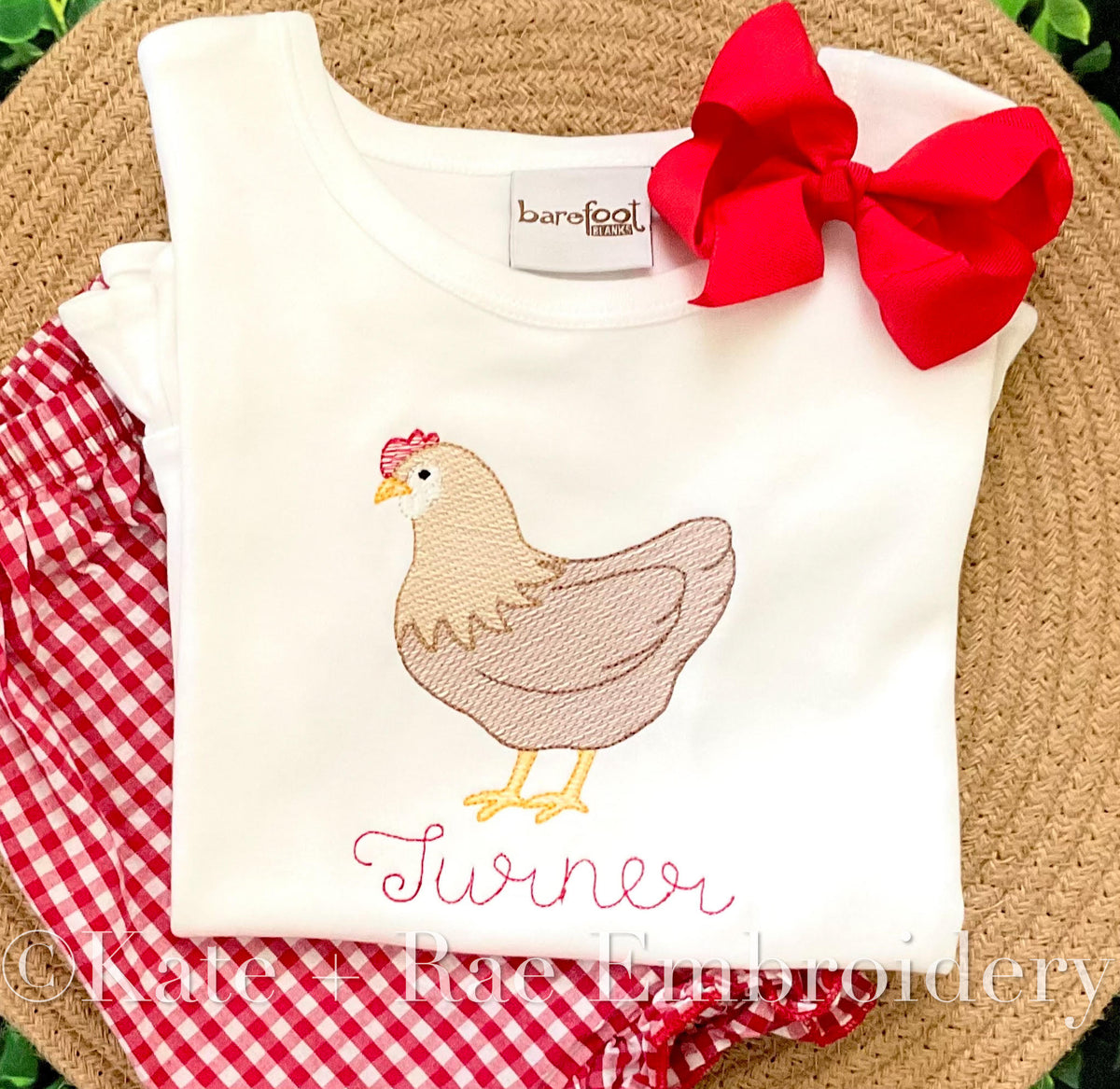 Chicken Sketch Stitch Embroidery Design: Tan sketch stitch hen above the name Turner in pink script on a white shirt with a red hair bow